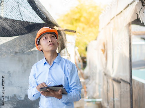 Young Asian foreman taking notes on his tablet, Business concept and technology.