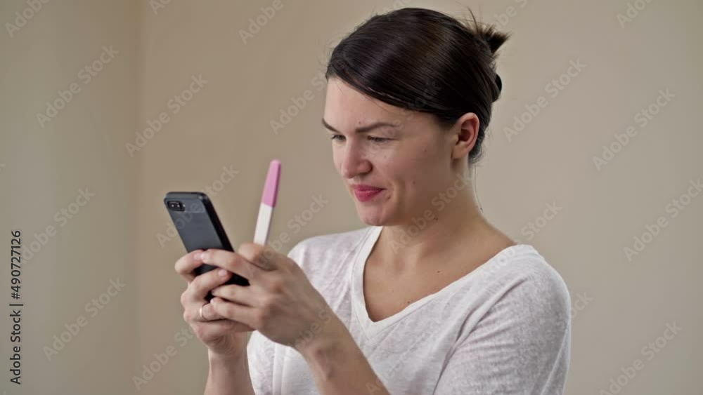 Young woman is happy to see a positive pregnancy test. She hurries to share her joy on the phone with a loved one. Young woman is happy to see a positive pregnancy test. She hurries to share her joy on the phone with a loved one.