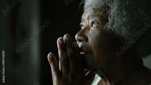 A senior African woman praying to God in meditation