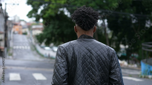 A pensive young black man walking outside in urban street a thoughtful African person