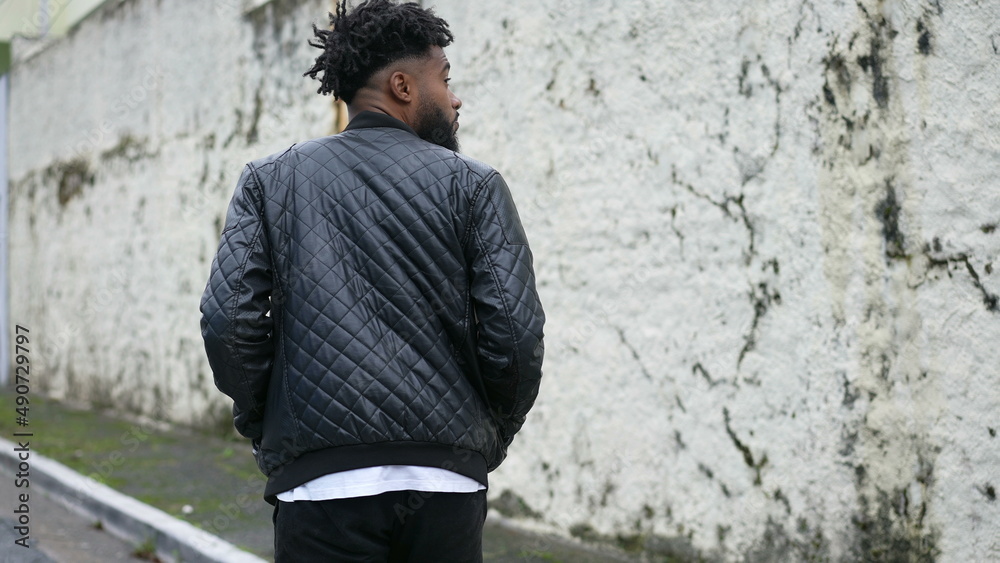 Obraz premium A contemplative African man walking in street