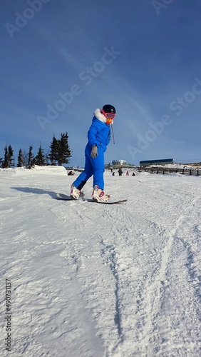 Young girl snowboarding. The girl is a child on a snowboard. Vertical photo