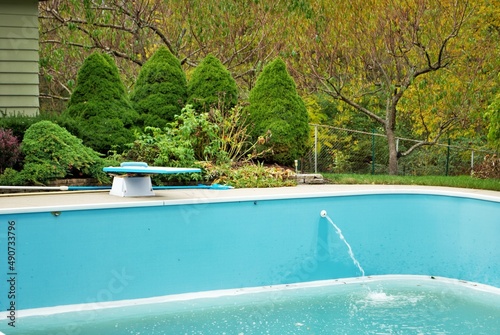 backyard swimming pool with diving board emptied out shutting down for winter