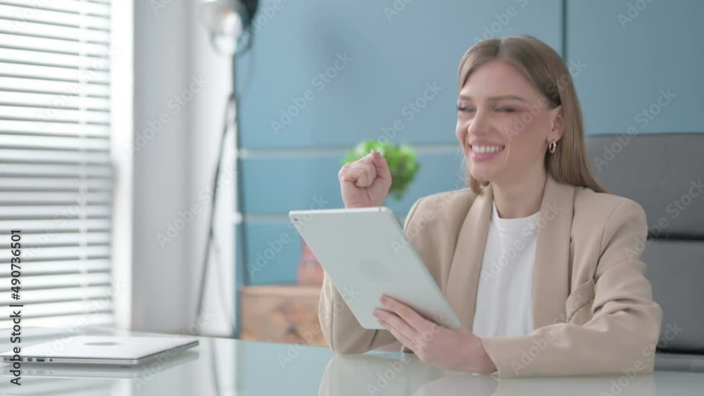 Businesswoman Celebrating Success on Tablet in Office Businesswoman Celebrating Success on Tablet in Office