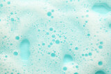 Background of blue soapy foam. Bulbs from gel and shampoo.