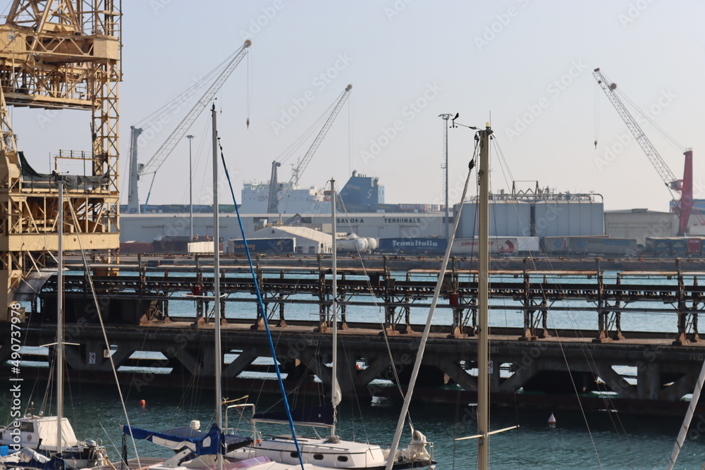 SAVONA, ITALY - February 12, 2022 - The port of Savona in the heart of the city on the italian riviera. Some old container lifter near the new area. Beautiful small boats parked. SAVONA, ITALY - February 12, 2022 - The port of Savona in the heart of the city on the italian riviera. Some old container lifter near the new area. Beautiful small boats parked.