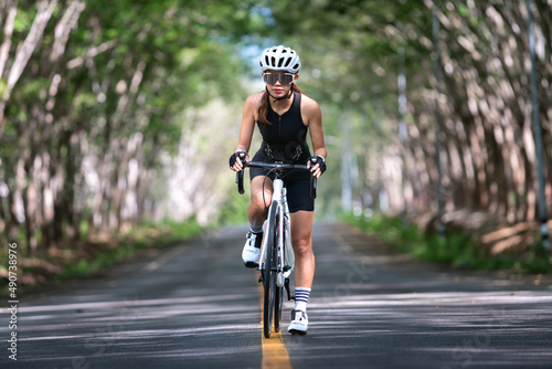 happy woman cycling athlete prepare for ride bicycle on street, road, with high speed for exercise hobby and competition in professional tour © kunchainub