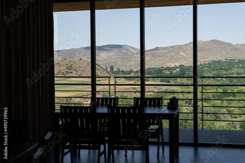 a table in a cafe where there is a large glazed window which is just a silhouette ai which can see a number of Georgian mountain landscapes