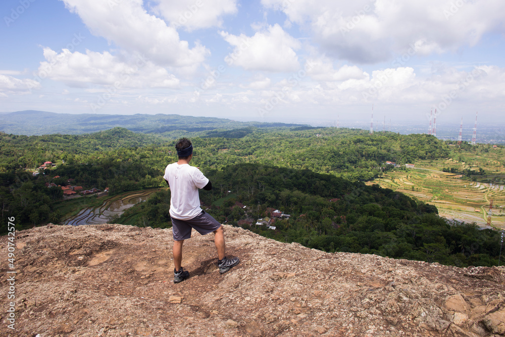 Fototapeta premium Man hiker with a backpack on top of the mountain back