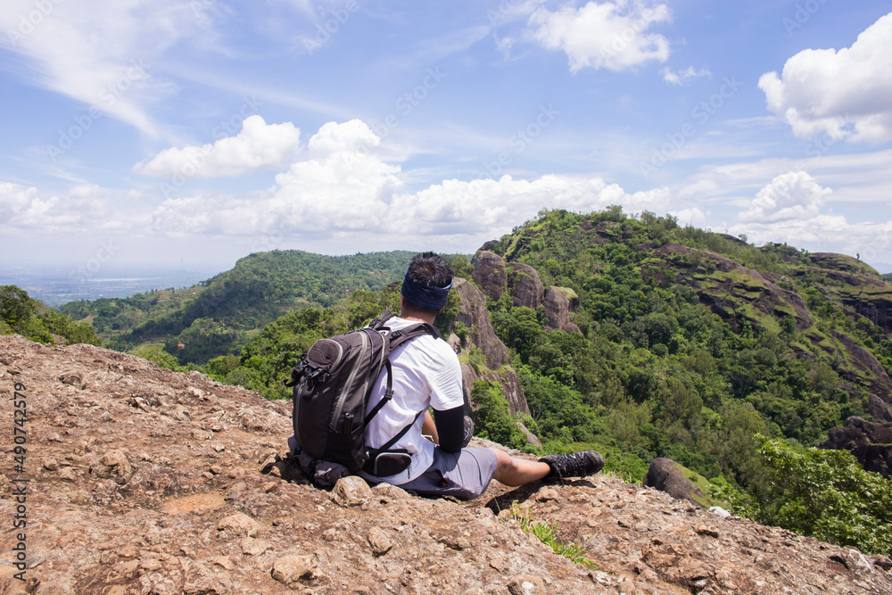 Man hiker with a backpack on top of the mountain back
Man hiker with a backpack on top of the mountain back