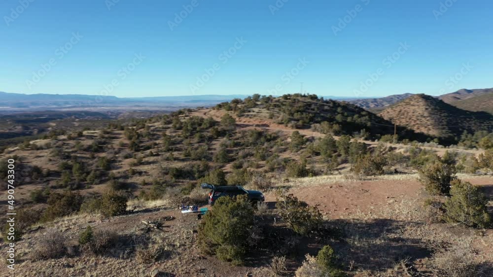 Aerial orbits 4x4 vehicle parked on scenic overlook in desert during winter Aerial orbits 4x4 vehicle parked on scenic overlook in desert during winter