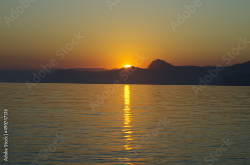 Peaceful sunset or sunrise on the seashore landscape in calm and quiet. Low sun  orange warm nighttime yellow light. Suitable for backgrounds and wallpapers. Soft focus