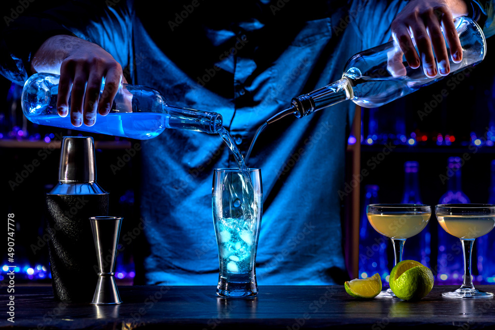 Bartender's hands serving cocktails on bar counter in a restaurant, pub