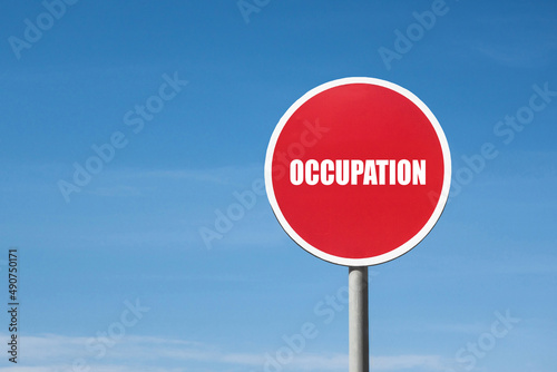 'Occupation' sign in red frame. Blue sky is on background © Poliorketes