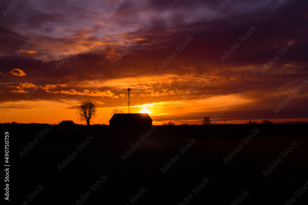 A beautiful, colorful spring sunrise over the field. Seasonal scenery of Northern Europe.