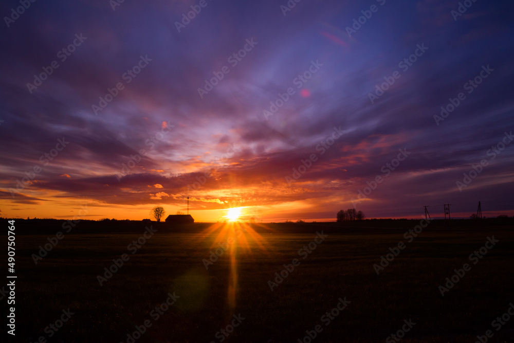 A beautiful, colorful spring sunrise over the field. Seasonal scenery of Northern Europe.