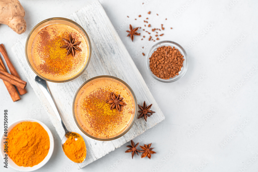Drink with turmeric, coffee and cinnamon on a dark background. Drink with turmeric, coffee and cinnamon on a dark background.