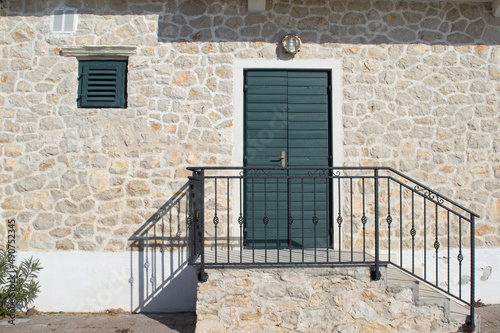 Tableau sur toile Authentic green door on a stone house characteristic for coastal area in Mediter