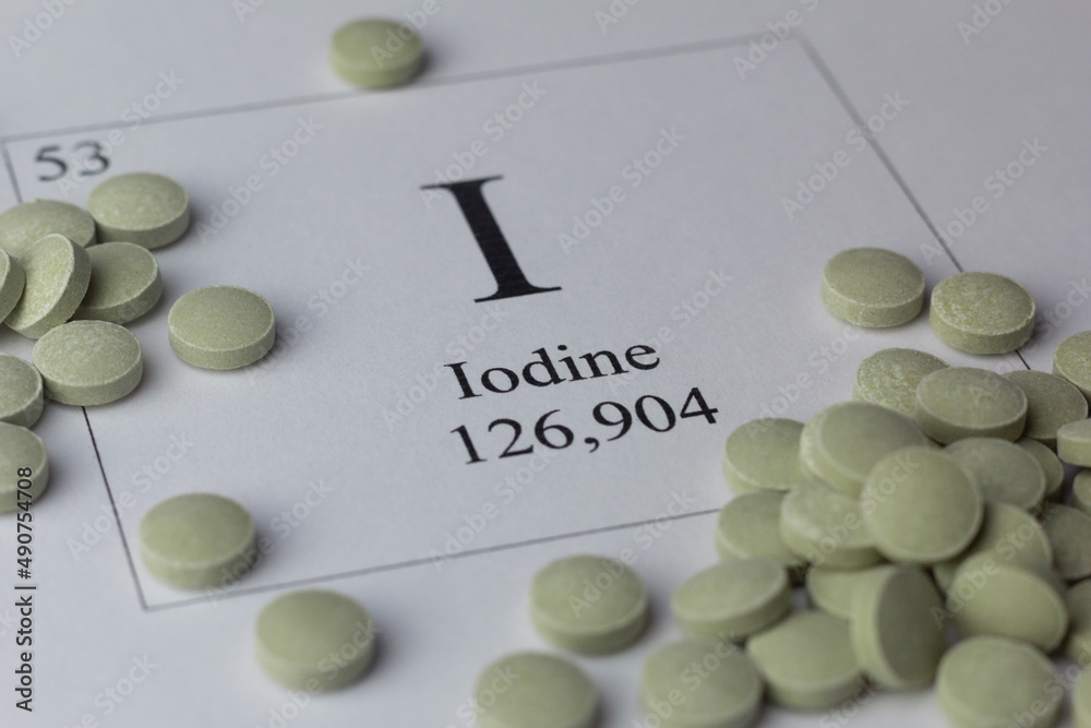 Closeup of iodine pills and periodic table.
