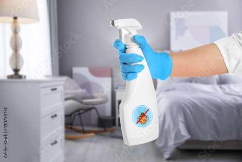 Foto Woman with anti bed bug spray in bedroom, closeup
