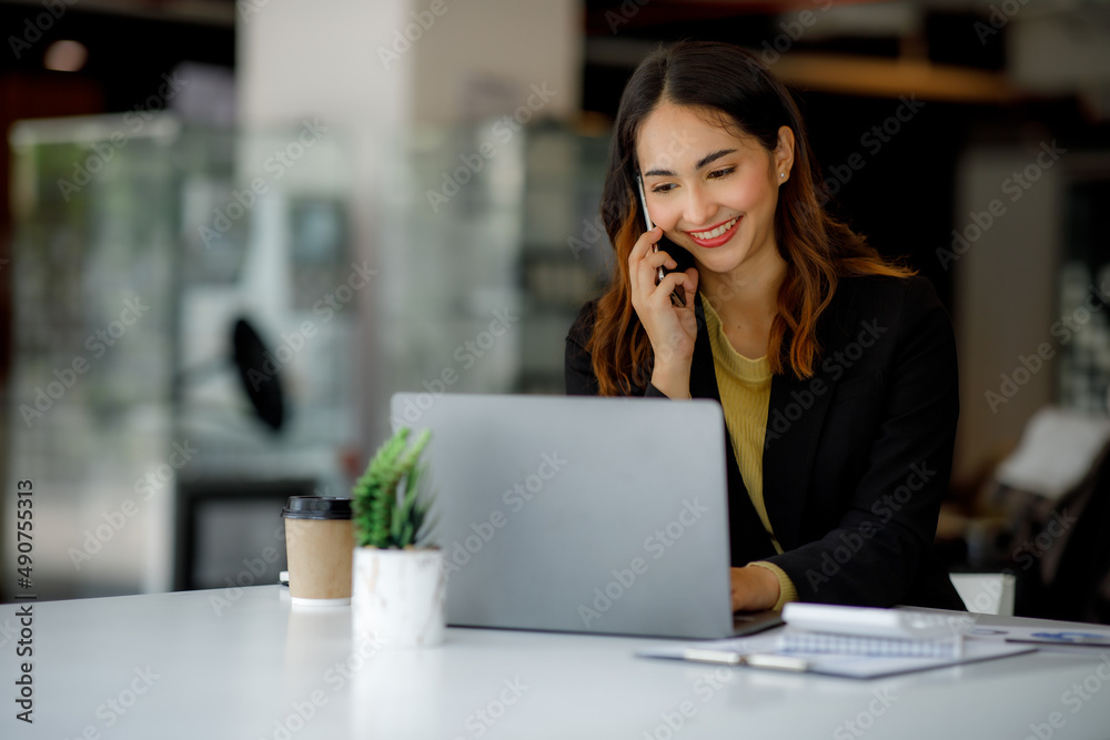Shot of Asian young business woman working on laptop computer in her workstation.Portrait of Business people employee freelance online marketing e-commerce telemarketing concept. Shot of Asian young business woman working on laptop computer in her workstation.Portrait of Business people employee freelance online marketing e-commerce telemarketing concept.