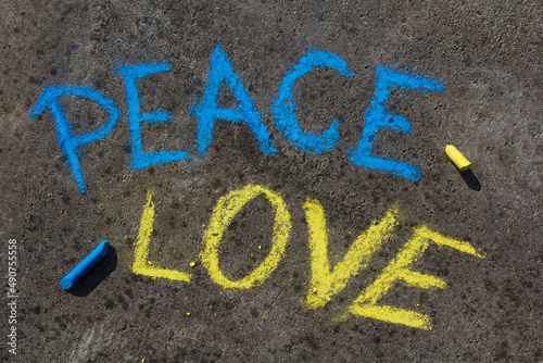 PEACE, LOVE inscription. Chalk drawing on sidewalk. The inscription in the colors of the Ukrainian flag