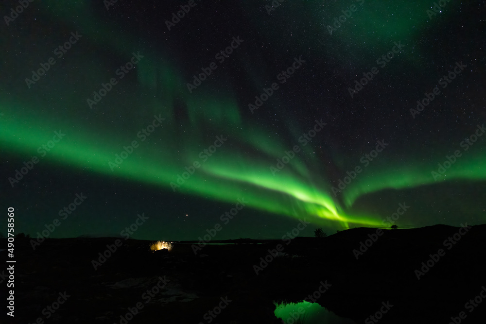Aurora borealis with stars and lake reflections