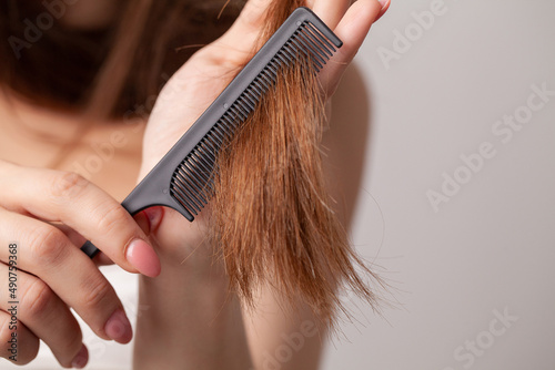 Woman on a white background with a comb for the hair, the hair problem