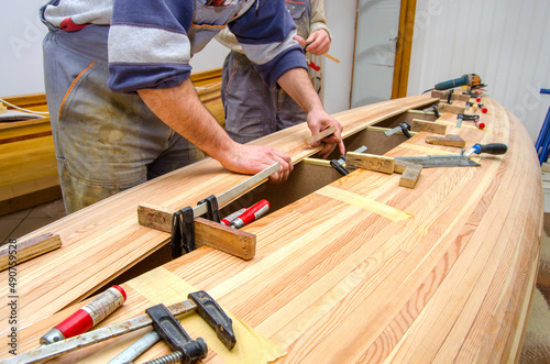 Carpenters making wooden boat in carpenter workshop