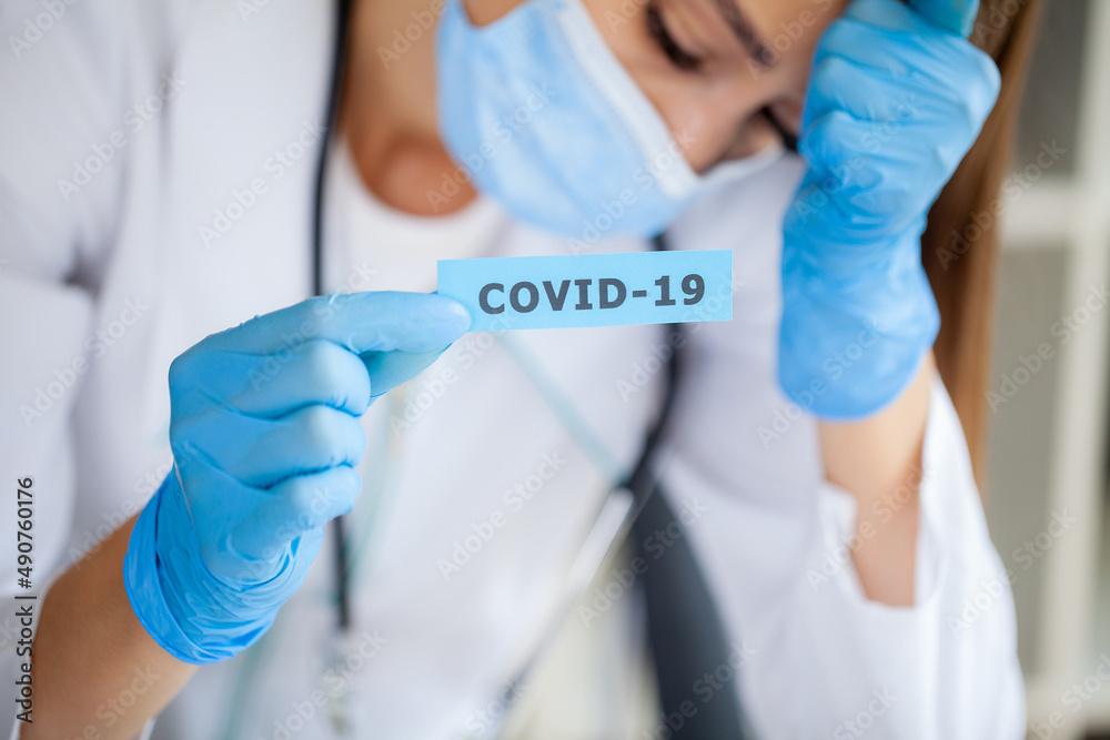 Doctor holding a paper card with text covid 19 Doctor holding a paper card with text covid 19