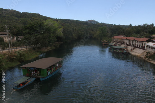 Aerial view of pier and tourist boat cruises through the Loboc green river in Loboc, Bohol, Philippines.