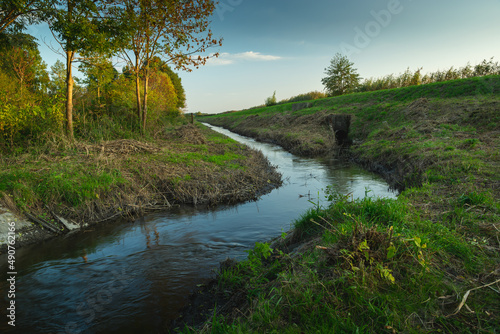 A bend in a small river and a green bank, Stankow, Poland