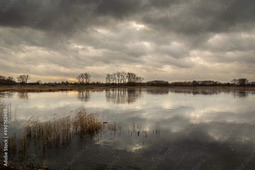 Dark clouds over the frozen lake, winter view
