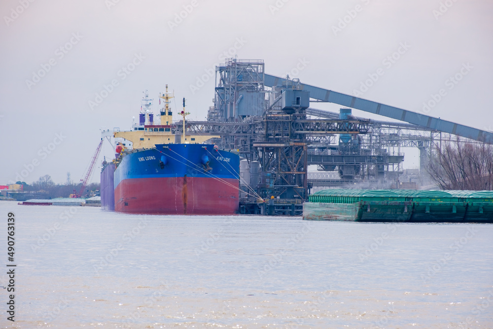 Stern of Hong Kong Registered Bulk Carrier King Loong and barges alongside Cargill grain