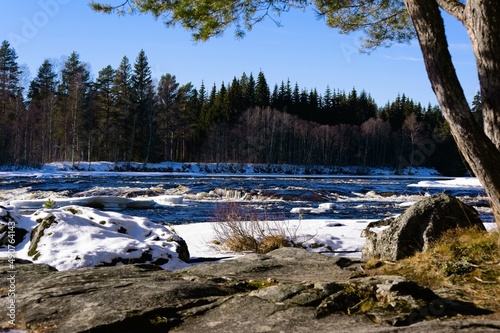 A partly frozen river with snow and ice on a sunny winterday in Dalarna,Sweden.