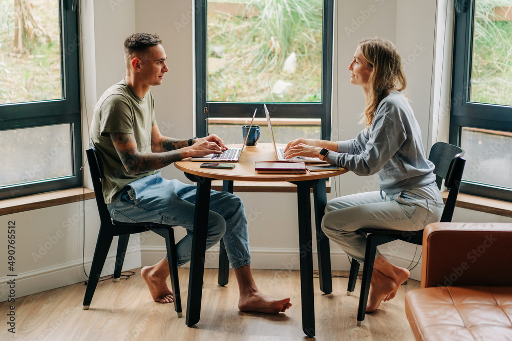 Business partners work on laptops while sitting in a stylish apartment, work from home, startup. Business partners work on laptops while sitting in a stylish apartment, work from home, startup.