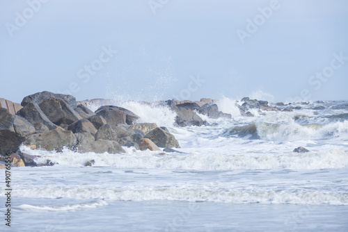 Rocks on the beach, water splashing, ocean, waves, blue sky