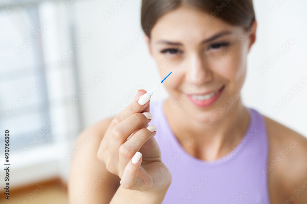 Woman uses brushes to clean the interdental spaces Woman uses brushes to clean the interdental spaces