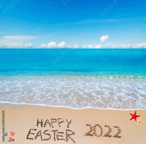 happy easter 2022 written on a tropical beach under clouds