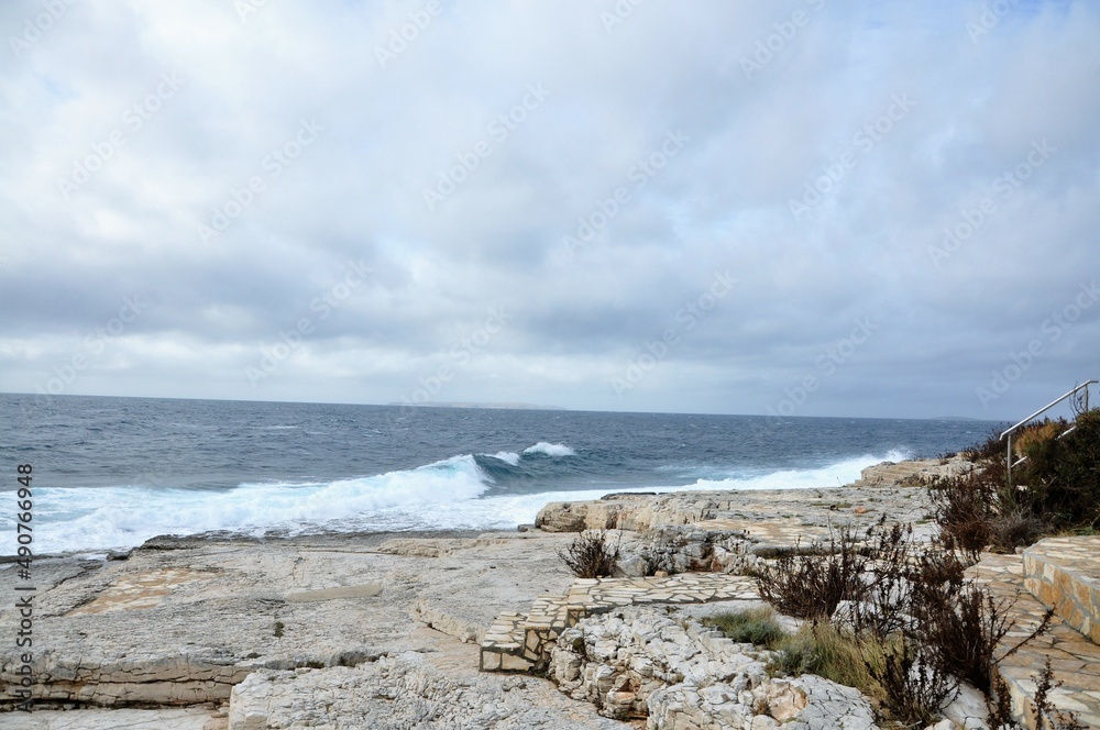 Strong wind and storm with big waves on Adriatic Sea,Losinj island rocky shore. Rough dangerous rocky sea coastline coast Suncana uvala on island Losinj in Croatia Europe