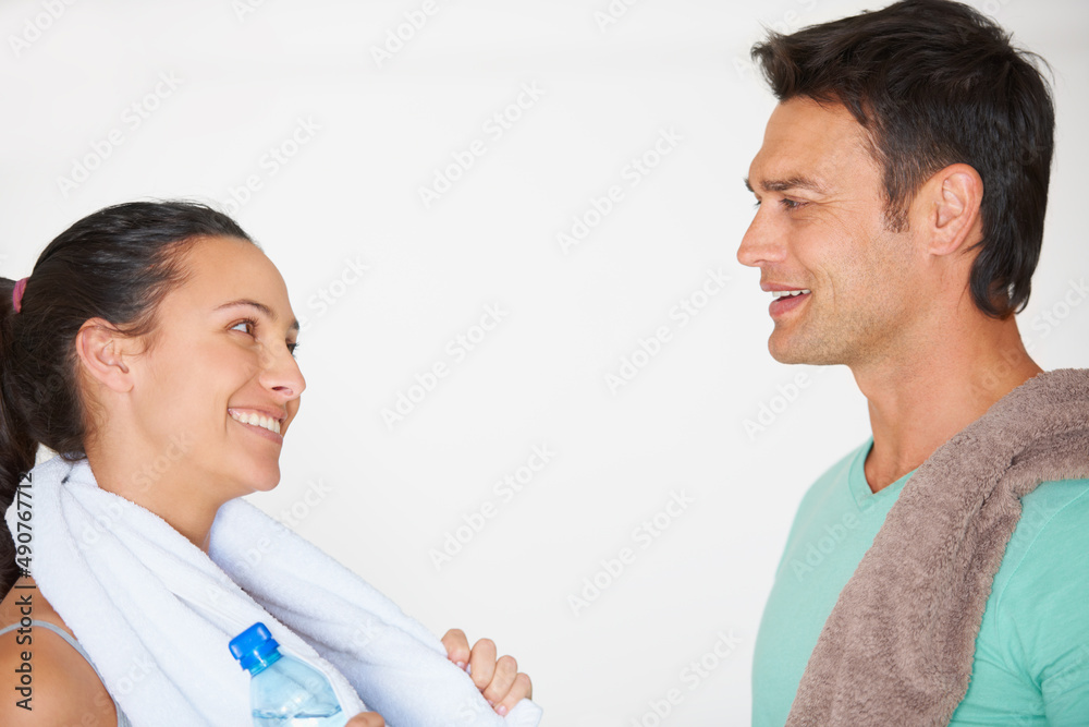 Talking about getting fit. Two young people talking to each other at the gym.