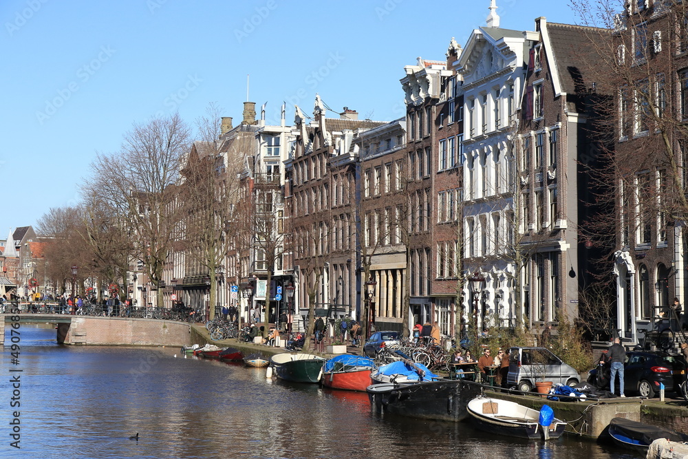 Amsterdam Kloveniersburgwal Canal View with Traditional Architecture, Boats and People, Netherlands