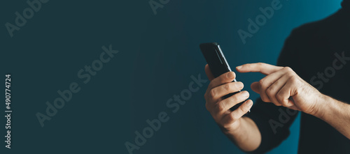 Fényképezés Using a smartphone by a young man on a blank background