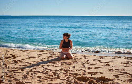A closeup of a young woman sitting on the beach