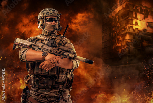 Special force soldier holding rifle against burning city