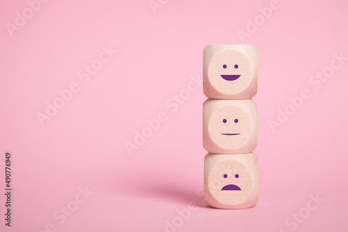 Wooden blocks with smilies faces symbols on Pinkbackground, evaluation, Increase rating, Customer experience satisfaction. Services rating concept, copy space