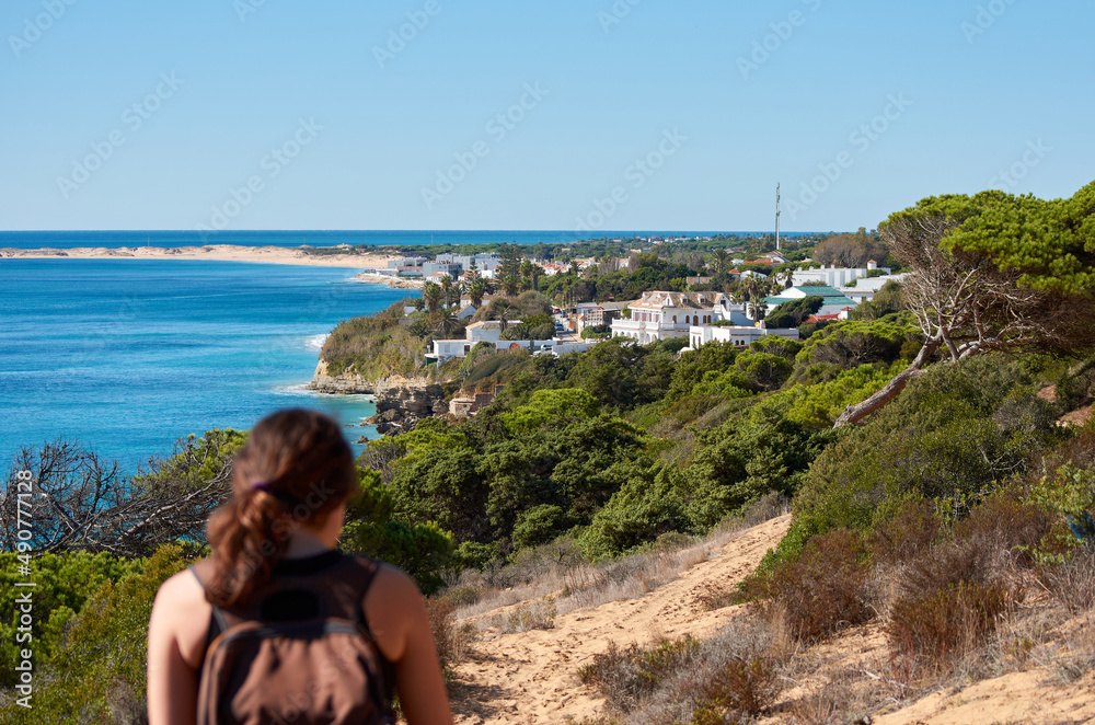 A young woman admiring the views of Los Caños de la Meca, a coast town located in the Cadiz Province, Andalusia, Spain