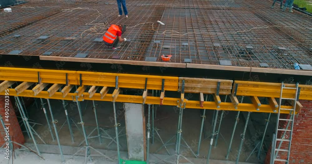 Builders make formwork at the construction site of a new stadium