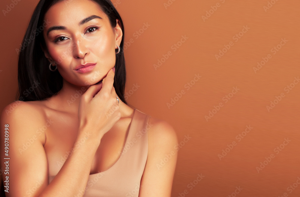 young pretty asian woman cheerful smiling posing on warm brown background, lifestyle people concept young pretty asian woman cheerful smiling posing on warm brown background, lifestyle people concept