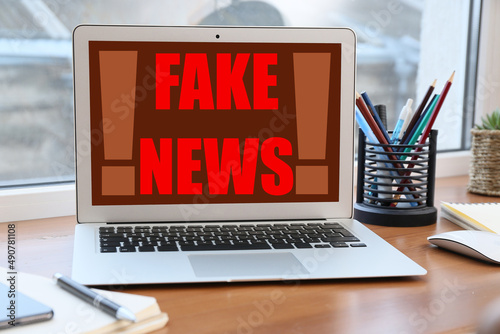 Schilderij op canvas Text FAKE NEWS on screen of laptop on table